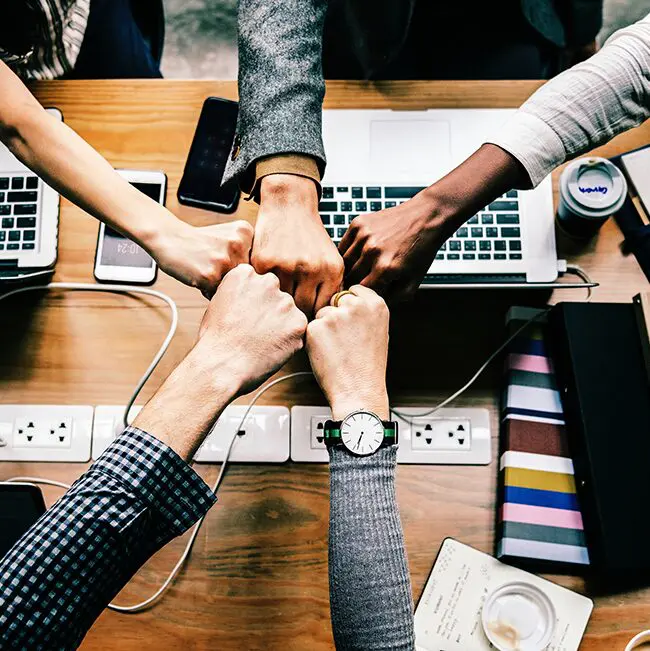 A group of people holding hands at a table.